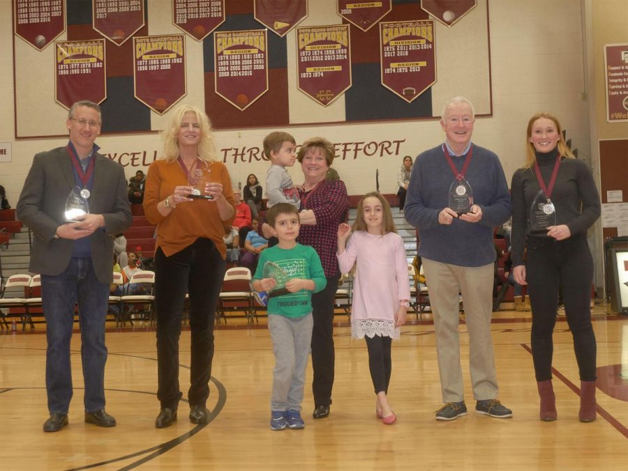 Members of the 2019 Hall of Fame class - and those standing in for members who could not attend - stand at mid-court to celebrate their achievement. 