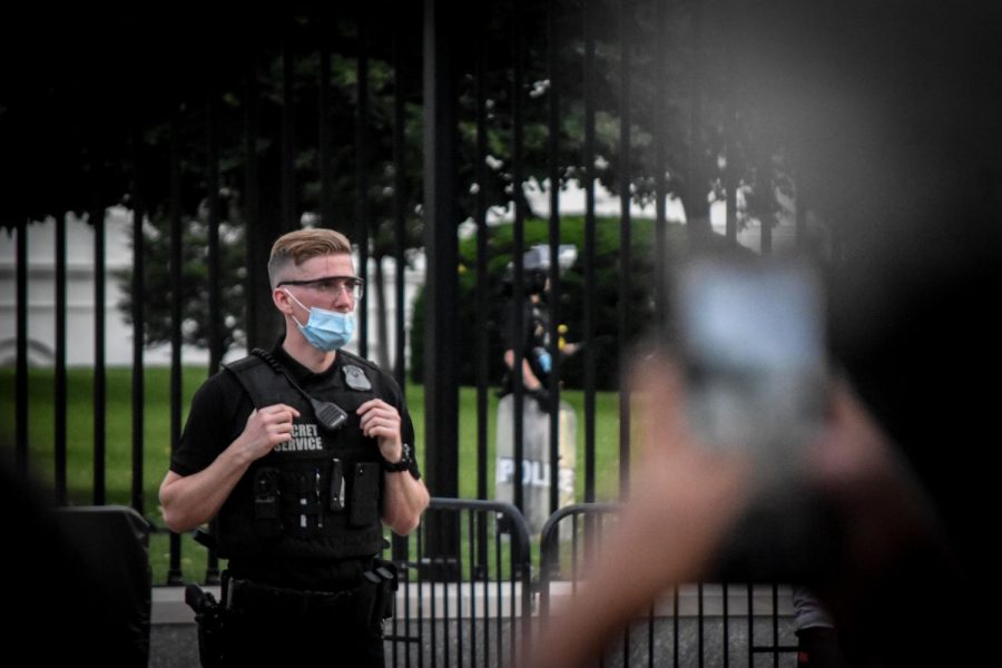 Armed Secret Service officers stand outside of the White House gate