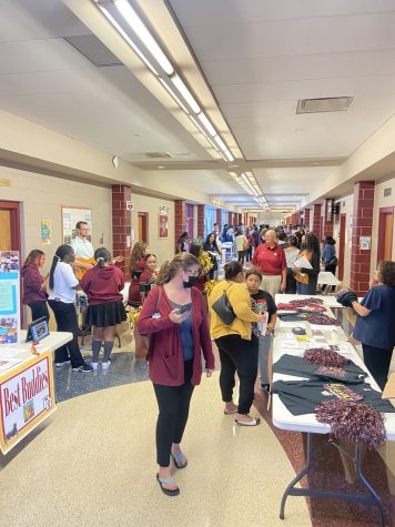 Students, Teachers and Staff in the main hallway looking at activities booths. 